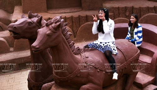 Du khách bên cặp song mã tạo nên bằng đất sét.