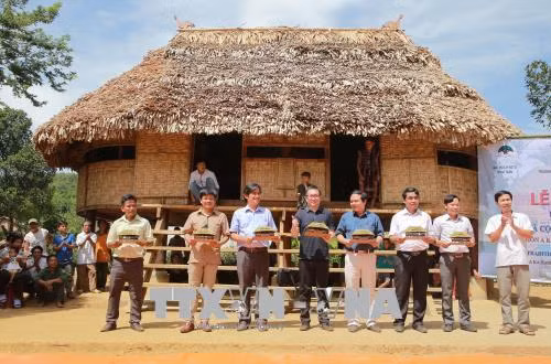 Địa phương tặng quà lưu niệm cho các đơn vị tài trợ và thiết kế xây dựng trong lễ khánh thành nhà Gươl. Ảnh: Hồ Cầu-TTXVN