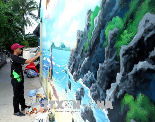 Các tình nguyện đang hoàn thiện những nét vẽ cuối cùng trên đảo Bé. Ảnh: Phước Ngọc-TTXVN Các tình nguyện đang hoàn thiện những nét vẽ cuối cùng trên đảo Bé. Ảnh: Phước Ngọc-TTXVN