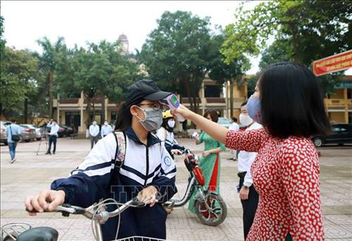 Trường THCS Bình Xuyên (huyện Bình Xuyên) thực hiện kiểm tra thân nhiệt cho học sinh trước khi vào lớp. Ảnh: Hoàng Hùng - TTXVN