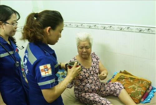 Nhân viên cấp cứu 115 - Bệnh viện Đa khoa Sài Gòn sơ cấp cứu tại nhà cho bệnh nhân. Ảnh: Đinh Hằng - TTXVN