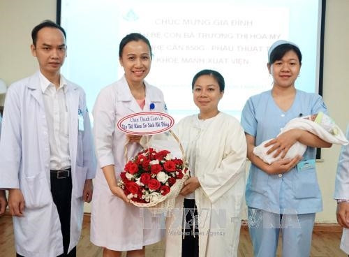 Sau một tháng phẫu thuật, bé gái đã khỏe mạnh và xuất viện về nhà trong niềm vui mừng của các bác sĩ và gia đình. Ảnh: Phương Vy-TTXVN.