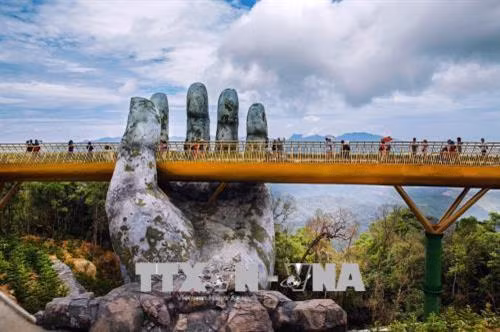Cầu Vàng nằm giữa trời mây mang lại trải nghiệm thú vị cho những du khách đến tham quan, ngắm cảnh tại đây. Ảnh: Trọng Đạt - TTXVN Cầu Vàng là điểm du lịch mới của Đà Nẵng đã và đang rất nổi tiếng cả trong và ngoài nước. Ảnh: Trọng Đạt - TTXVN Cầu Vàng là điểm du lịch mới của Đà Nẵng đã và đang rất nổi tiếng cả trong và ngoài nước. Ảnh: Trọng Đạt - TTXVN Du khách đi bộ trên cầu như đi trên "dải lụa được nâng giữ bởi đôi tay của thần núi". Ảnh: Trọng Đạt - TTXVN Cầu Vàng nằm ở khu vực vườn Thiên Thai của Sun World Ba Na Hills. Cầu được kết nối với nhà ga Marseille và Bordeaux để đưa khách từ khu vực chân núi hay làng Pháp thăm vườn hoa. Giữa không trung, cây cầu như một "dải lụa" vàng rực rỡ. Ảnh: Trọng Đạt - TTXVN
