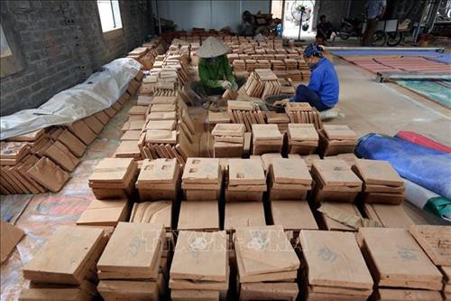 Các mảnh gốm dày tới 10cm được vệ sinh trước khi ghép làm tranh khổ lớn. Ảnh: Danh Lam - TTXVN