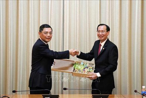 Ông Lê Thanh Liêm, Phó Chủ tịch Thường trực UBND Thành phố Hồ Chí Minh (phải) tặng quà lưu niệm là sản phẩm nông nghiệp của Thành phố cho ông Bành Trầm Lôi, Phó Thị trưởng Thượng Hải, Trung Quốc (trái). Ảnh: Xuân Khu-TTXVN.