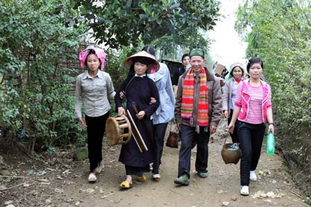 Cô dâu (mặc áo Thái màu đen, tay cầm hương) được ông mối (khoác khăn) cùng hai họ đưa về nhà chồng