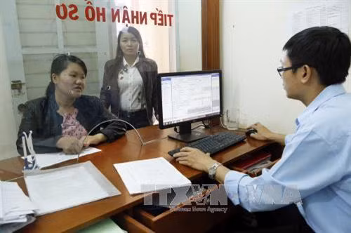 Khách hàng giao dịch tại bộ phận Một cửa - BHXH huyện Đăk Đoa (Gia Lai). Ảnh: Dương Ngọc - TTXVN