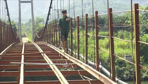 Tiến hành kiểm tra thi công cầu treo xuống cấp nghiêm trọng. Ảnh: Thanh Hải – TTXVN