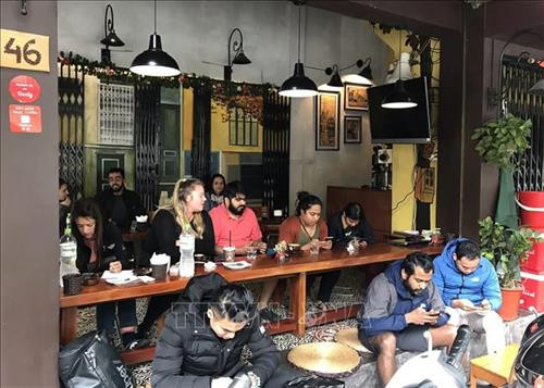 Khách du lịch quốc tế thưởng thức cà phê trên phố Nguyễn Hữu Huân (Hà Nội). Ảnh: Minh Quyết - TTXVN Khách du lịch quốc tế thưởng thức cà phê trên phố Nguyễn Hữu Huân (Hà Nội). Ảnh: Minh Quyết - TTXVN