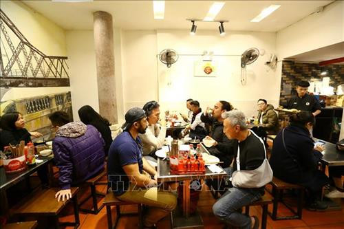 Khách du lịch quốc tế ăn trưa tại quán cơm trên phố Đào Duy Từ (Hà Nội). Ảnh: Minh Quyết – TTXVN Khách du lịch quốc tế ăn trưa tại quán cơm trên phố Đào Duy Từ (Hà Nội). Ảnh: Minh Quyết – TTXVN