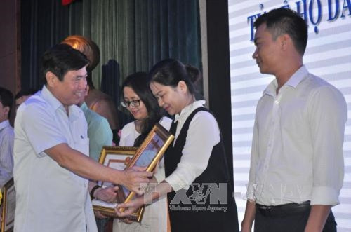 Chủ tịch UBND Thành phố Hồ Chí Minh Nguyễn Thành Phong trao bằng khen cho các tập thể có thành tích xuất sắc. Ảnh: Hoàng Hải-TTXVN