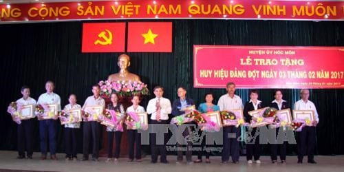 Lãnh đạo huyện Hóc Môn trao huy hiệu đảng cho các đồng chí lão thành cách mạng. Ảnh: Thanh Vũ-TTXVN