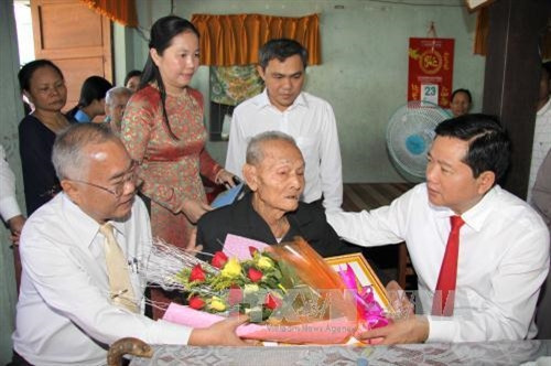 Đồng chí Đinh La Thăng, Bí thư Thành ủy Thành phố Hồ Chí Minh đến xã Thới Tam Thôn, huyện Hóc Môn trao huy hiệu 70 năm tuổi đảng cho đồng chí Nguyễn Văn Hoảnh (sinh năm 1928). Ảnh: Thanh Vũ-TTXVN