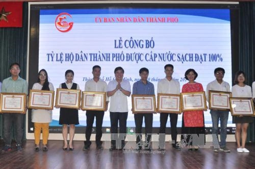 Chủ tịch UBND Thành phố Hồ Chí Minh Nguyễn Thành Phong trao bằng khen cho các tập thể có thành tích xuất sắc. Ảnh: Hoàng Hải-TTXVN