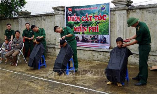 Các chiến sĩ cắt tóc cho người dân. Ảnh: Việt Hoàng – TTXVN