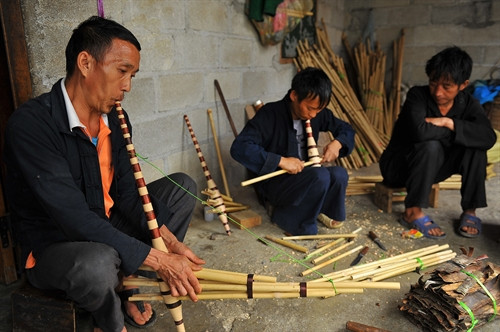 Người mua thử âm thanh của cây khèn vừa mới làm xong Người mua thử âm thanh của cây khèn vừa mới làm xong