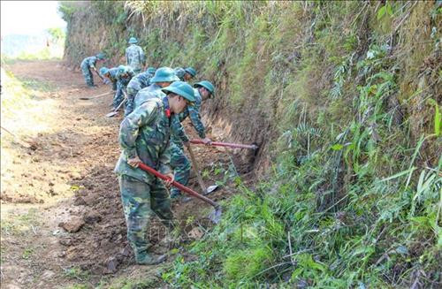Các chiến sĩ san sửa con đường từ bản Huổi Chan 2 ra Quốc lộ 12. Ảnh: Xuân Tư – TTXVN Các chiến sĩ san sửa con đường từ bản Huổi Chan 2 ra Quốc lộ 12. Ảnh: Xuân Tư – TTXVN