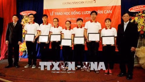 Đại diện Ban tổ chức trao học bổng cho sinh viên. Ảnh: Thu Hoài – TTXVN