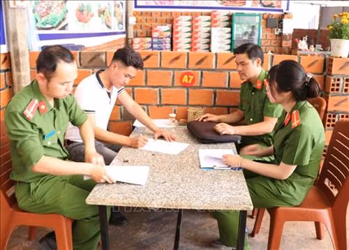 Công an huyện Đăk Đoa đến tuyên truyền và hướng dẫn cac chủ quán ký cam kết đảm bảo trật tự an toàn xã hội trên địa bàn. Ảnh: Hồng Điệp - TTXVN