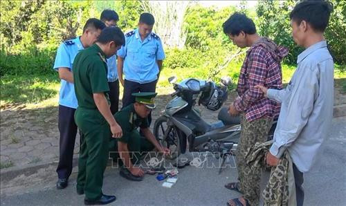 Lực lượng chức năng kiểm tra xe máy của đối tượng Lò Văn Sáng (áo ca rô). Ảnh: TTXVN phát