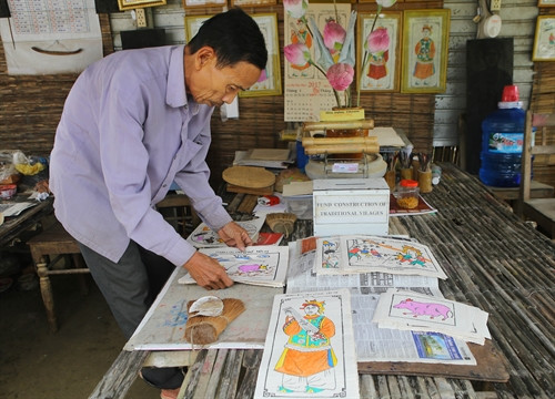 Nghệ nhân Kỳ Hữu Phước với bộ tranh ông vừa mới vẽ.