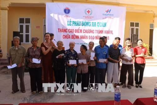 Trao quà cho các hộ gia đình có hoàn cảnh khó khăn xã Liên Lộc. Ảnh: Khiếu Tư - TTXVN