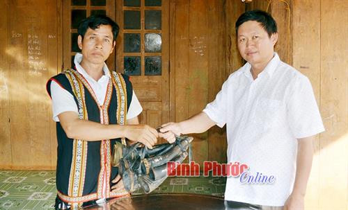 Ông Điểu Hoi bàn giao bộ kèn sừng trâu của người S’tiêng cho cán bộ Phòng Di sản