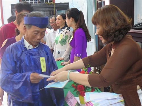 Phát phiếu bầu cử cho cử tri. Ảnh: Đoàn Hữu Trung- TTXVN