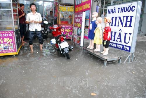 Một cửa hàng kinh doanh trên đường Phan Huy Ích (thuộc quận Tân Bình) bị nước tràn vào bên trong ảnh hưởng đến buôn bán. Ảnh: Mạnh Linh-TTXVN