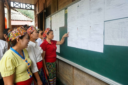 Cử tri dân tộc Mông xem dánh sách các ứng cử viên trước khi tiến hành bầu cử tại điểm bỏ phiếu sớm số 5 bản Huổi Mới, xã Hữu Khuông (huyện Tương Dương). Ảnh: Tá Chuyên- TTXVN
