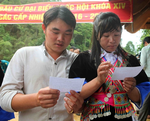 Cử tri dân tộc Mông kiểm tra các thông tin trên thẻ cử tri tại điểm bỏ phiếu số 1 xã biên giới Tri Lễ, huyện Quế Phong. Ảnh: Thanh Tùng- TTXVN