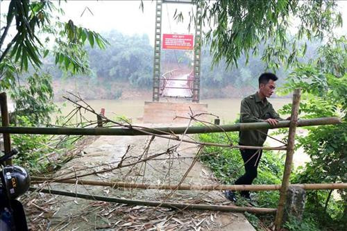 Do cầu treo bị hư hỏng nặng, rất nguy hiểm, nên xã Văn Luông đã cắt cử lực lượng công an xã ứng trực bên cầu, ngăn người dân không bắc thang leo lên cầu để qua sông. Ảnh: Trung Kiên - TTXVN. Do cầu treo bị hư hỏng nặng, rất nguy hiểm, nên xã Văn Luông đã cắt cử lực lượng công an xã ứng trực bên cầu, ngăn người dân không bắc thang leo lên cầu để qua sông. Ảnh: Trung Kiên - TTXVN.
