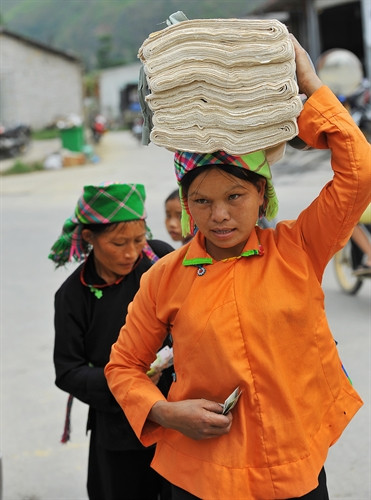Những tấm vải lanh hoàn thiện sau khi trải qua nhiều công đoạn được người phụ nữ mang ra chợ phiên để bán.