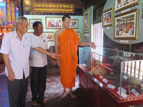 Đại đức Sơn Diễn giới thiệu nông cụ của người Khmer được trưng bày tại chùa Kompi Preak Chrou (chùa Siêm Cán), tỉnh Bạc Liêu