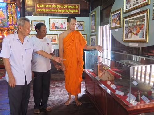 Đại đức Sơn Diễn giới thiệu nông cụ của người Khmer được trưng bày tại chùa Kompi Preak Chrou (chùa Siêm Cán), tỉnh Bạc Liêu