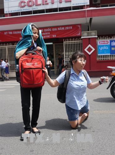 Thí sinh Phạm Thị Thu Thủy, (phải) hiện đang sinh sống tại Làng trẻ Hòa Bình, Thành phố Hồ Chí Minh dự thi tại điểm thi Trường Trung học cơ sở Colette. Ảnh: TTXVN phát