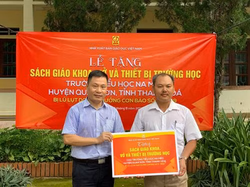 Ông Nguyễn Quốc Hồng – Chủ tịch Công đoàn Cơ sở NXB Giáo dục Việt Nam trao tặng quà cho thầy hiệu trưởng Chung Trường Thành - đại diện trường Tiểu học Na Mèo. Ảnh: Bạch Kim