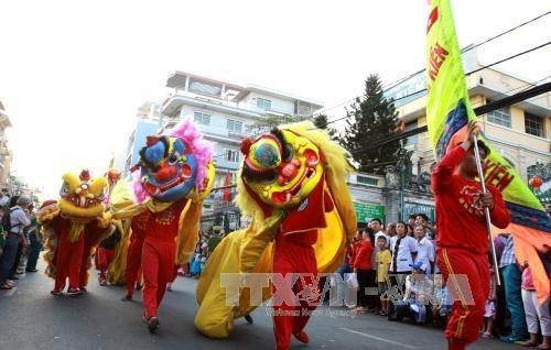 Các đoàn lân, sư, rồng biểu diễn qua các đường phố lớn của Quận 5. Ảnh: Phương Vy - TTXVN