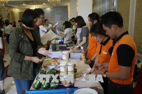 Đại biểu tìm hiểu về sản phẩm được chế biến từ thịt lợn của các doanh nghiệp. Ảnh: Tiến Lực – TTXVN