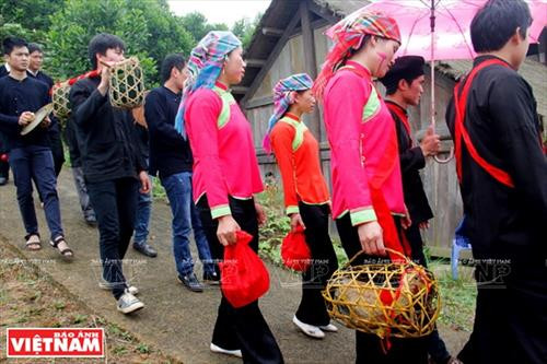 Sợi dây hồng cùng bàn lễ bày ngay trước cửa nhà gái để chuẩn bị đón nhà trai sang rước dâu. Rượu, nước lã và mấy cái chén làm bằng thân tre đặt trên bàn lễ. Nhà trai trên đường đi tới nhà gái đón dâu. Đội pí lè trong đoàn đón dâu của nhà trai. Đoàn rước dâu vừa đi vừa nổi nhạc thể hiện niềm vui mừng. Nhà gái hát đối khi nhà trai tới đón dâu Nhà trai hát đối lại. Gia đình nhà gái bôi phẩm đỏ lên mặt các thành viên trong đoàn nhà trai. Nhà trai trao lễ vật ngày cưới cho nhà gái. Sợi dây hồng cùng bàn lễ bày ngay trước cửa nhà gái để chuẩn bị đón nhà trai sang rước dâu. Rượu, nước lã và mấy cái chén làm bằng thân tre đặt trên bàn lễ. Nhà trai trên đường đi tới nhà gái đón dâu. Đội pí lè trong đoàn đón dâu của nhà trai. Đoàn rước dâu vừa đi vừa nổi nhạc thể hiện niềm vui mừng. Nhà gái hát đối khi nhà trai tới đón dâu Nhà trai hát đối lại. Gia đình nhà gái bôi phẩm đỏ lên mặt các thành viên trong đoàn nhà trai. Nhà trai trao lễ vật ngày cưới cho nhà gái.