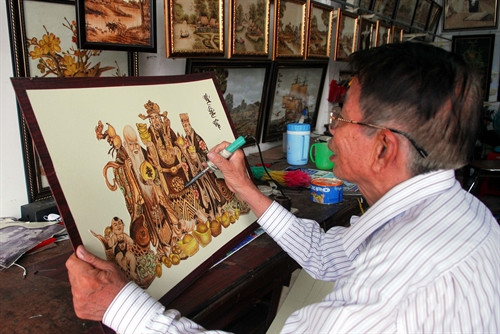 Ông Tạng dùng que hàn điện để vẽ tranh.