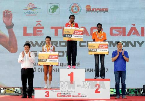 Phó Chủ tịch UBND Thành phố Hồ Chí Minh Huỳnh Cách Mạng (trái) trao giải thưởng cho các vận động viên nữ chuyên nghiệp đạt giải cao ở cự ly 42km. Ảnh: An Hiếu – TTXVN
