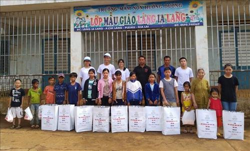 Lê Văn Phúc (áo trắng đội mũ hàng sau) trong những đợt từ thiện tại địa phương. Ảnh: TTXVN phát