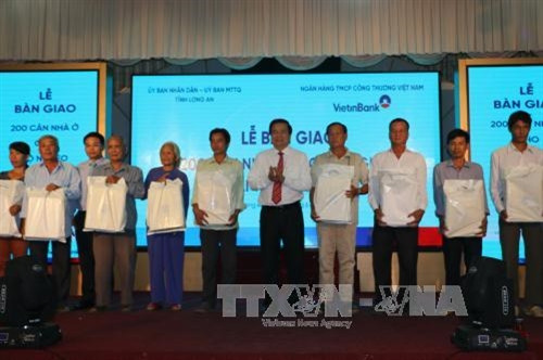 Bí thư tỉnh ủy Long An và lãnh đạo UBND tỉnh, Ngân hàng Viettinbank trao quà cho hộ nghèo. Ảnh: Thanh Bình - TTXVN