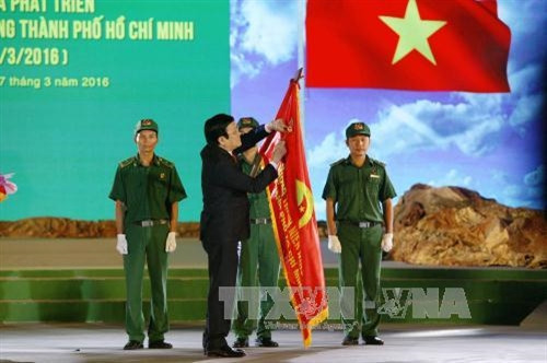 Chủ tịch nước Trương Tấn Sang trao Huân Chương Độc Lập hạng 3 lên lá cờ truyền thống của Lực lượng Thanh niên Xung phong Thành phố Hồ Chí Minh. Ảnh: Thanh Vũ – TTXVN
