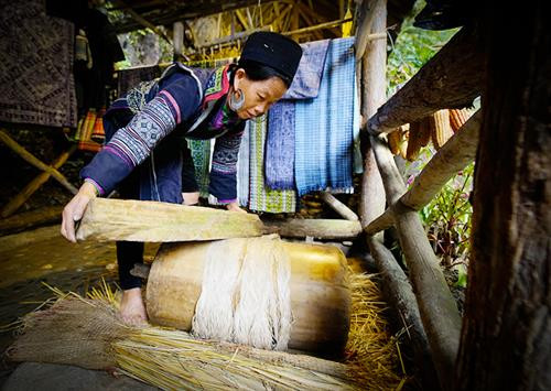 Việc đầu tiên phụ nữ Mông làm là thu hoạch cây lanh và được phơi thành những đụm to ở bất cứ khoảng đất rộng nào. Khi lanh đã đủ khô được mang về nhà, tước vỏ... …tiếp đó là giã lanh và nối sợi. Đây là công đoạn vất vả và tốn nhiều công sức nhất, sau khi giã cho mềm là tỉ mẩn nối những sợi lanh sao cho đều và đẹp. Phụ nữ Mông luôn tranh thủ trên đường lên nương, xuống chợ hay bất cứ khi nào, miễn đôi tay được "rảnh" là lại thoăn thoắt nối sợi, cuộn thành những búi nhỏ ở tay. Sau khi se và nối sợi bằng tay, sợi được đưa lên guồng se tiếp một lần nữa rồi cho vào guồng thu sợi. Qua các công đoạn sơ chế, sợi có màu trắng, mịn, dai và tiếp tục lăn mỏng, phẳng hơn, sau đó được xếp thành con chỉ dệt và dệt thành vải. Để tạo hoa văn, họa tiết, người Mông thường dùng kỹ thuật vẽ sáp ong do những người lớn tuổi có kinh nghiệm lâu năm thực hiện. Nhuộm chàm là công đoạn không thể thiếu. Sau khi nhuộm chàm, những tấm vải được phơi khô và giặt tẩy sáp... ... tiếp tục giặt nhiều lần rồi lăn để tạo độ phẳng và mịn. Những tấm vải thổ cẩm hoàn thành chứa đựng trong đó bao mồ hôi, công sức của phụ nữ Mông. Việc đầu tiên phụ nữ Mông làm là thu hoạch cây lanh và được phơi thành những đụm to ở bất cứ khoảng đất rộng nào. Khi lanh đã đủ khô được mang về nhà, tước vỏ... …tiếp đó là giã lanh và nối sợi. Đây là công đoạn vất vả và tốn nhiều công sức nhất, sau khi giã cho mềm là tỉ mẩn nối những sợi lanh sao cho đều và đẹp. Phụ nữ Mông luôn tranh thủ trên đường lên nương, xuống chợ hay bất cứ khi nào, miễn đôi tay được "rảnh" là lại thoăn thoắt nối sợi, cuộn thành những búi nhỏ ở tay. Sau khi se và nối sợi bằng tay, sợi được đưa lên guồng se tiếp một lần nữa rồi cho vào guồng thu sợi. Qua các công đoạn sơ chế, sợi có màu trắng, mịn, dai và tiếp tục lăn mỏng, phẳng hơn, sau đó được xếp thành con chỉ dệt và dệt thành vải. Để tạo hoa văn, họa tiết, người Mông thường dùng kỹ thuật vẽ sáp ong do những người lớn tuổi có kinh nghiệm lâu năm thực hiện. Nhuộm chàm là công đoạn không thể thiếu. Sau khi nhuộm chàm, những tấm vải được phơi khô và giặt tẩy sáp... ... tiếp tục giặt nhiều lần rồi lăn để tạo độ phẳng và mịn. Những tấm vải thổ cẩm hoàn thành chứa đựng trong đó bao mồ hôi, công sức của phụ nữ Mông.