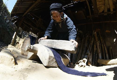 Việc đầu tiên phụ nữ Mông làm là thu hoạch cây lanh và được phơi thành những đụm to ở bất cứ khoảng đất rộng nào. Khi lanh đã đủ khô được mang về nhà, tước vỏ... …tiếp đó là giã lanh và nối sợi. Đây là công đoạn vất vả và tốn nhiều công sức nhất, sau khi giã cho mềm là tỉ mẩn nối những sợi lanh sao cho đều và đẹp. Phụ nữ Mông luôn tranh thủ trên đường lên nương, xuống chợ hay bất cứ khi nào, miễn đôi tay được "rảnh" là lại thoăn thoắt nối sợi, cuộn thành những búi nhỏ ở tay. Sau khi se và nối sợi bằng tay, sợi được đưa lên guồng se tiếp một lần nữa rồi cho vào guồng thu sợi. Qua các công đoạn sơ chế, sợi có màu trắng, mịn, dai và tiếp tục lăn mỏng, phẳng hơn, sau đó được xếp thành con chỉ dệt và dệt thành vải. Để tạo hoa văn, họa tiết, người Mông thường dùng kỹ thuật vẽ sáp ong do những người lớn tuổi có kinh nghiệm lâu năm thực hiện. Nhuộm chàm là công đoạn không thể thiếu. Sau khi nhuộm chàm, những tấm vải được phơi khô và giặt tẩy sáp... ... tiếp tục giặt nhiều lần rồi lăn để tạo độ phẳng và mịn. Những tấm vải thổ cẩm hoàn thành chứa đựng trong đó bao mồ hôi, công sức của phụ nữ Mông. Việc đầu tiên phụ nữ Mông làm là thu hoạch cây lanh và được phơi thành những đụm to ở bất cứ khoảng đất rộng nào. Khi lanh đã đủ khô được mang về nhà, tước vỏ... …tiếp đó là giã lanh và nối sợi. Đây là công đoạn vất vả và tốn nhiều công sức nhất, sau khi giã cho mềm là tỉ mẩn nối những sợi lanh sao cho đều và đẹp. Phụ nữ Mông luôn tranh thủ trên đường lên nương, xuống chợ hay bất cứ khi nào, miễn đôi tay được "rảnh" là lại thoăn thoắt nối sợi, cuộn thành những búi nhỏ ở tay. Sau khi se và nối sợi bằng tay, sợi được đưa lên guồng se tiếp một lần nữa rồi cho vào guồng thu sợi. Qua các công đoạn sơ chế, sợi có màu trắng, mịn, dai và tiếp tục lăn mỏng, phẳng hơn, sau đó được xếp thành con chỉ dệt và dệt thành vải. Để tạo hoa văn, họa tiết, người Mông thường dùng kỹ thuật vẽ sáp ong do những người lớn tuổi có kinh nghiệm lâu năm thực hiện. Nhuộm chàm là công đoạn không thể thiếu. Sau khi nhuộm chàm, những tấm vải được phơi khô và giặt tẩy sáp... ... tiếp tục giặt nhiều lần rồi lăn để tạo độ phẳng và mịn. Những tấm vải thổ cẩm hoàn thành chứa đựng trong đó bao mồ hôi, công sức của phụ nữ Mông.