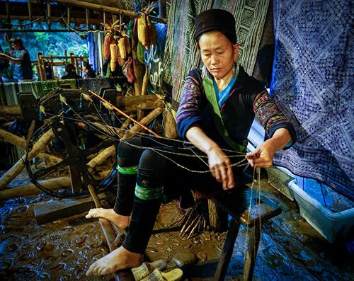 Việc đầu tiên phụ nữ Mông làm là thu hoạch cây lanh và được phơi thành những đụm to ở bất cứ khoảng đất rộng nào. Khi lanh đã đủ khô được mang về nhà, tước vỏ... …tiếp đó là giã lanh và nối sợi. Đây là công đoạn vất vả và tốn nhiều công sức nhất, sau khi giã cho mềm là tỉ mẩn nối những sợi lanh sao cho đều và đẹp. Phụ nữ Mông luôn tranh thủ trên đường lên nương, xuống chợ hay bất cứ khi nào, miễn đôi tay được "rảnh" là lại thoăn thoắt nối sợi, cuộn thành những búi nhỏ ở tay. Sau khi se và nối sợi bằng tay, sợi được đưa lên guồng se tiếp một lần nữa rồi cho vào guồng thu sợi. Qua các công đoạn sơ chế, sợi có màu trắng, mịn, dai và tiếp tục lăn mỏng, phẳng hơn, sau đó được xếp thành con chỉ dệt và dệt thành vải. Để tạo hoa văn, họa tiết, người Mông thường dùng kỹ thuật vẽ sáp ong do những người lớn tuổi có kinh nghiệm lâu năm thực hiện. Nhuộm chàm là công đoạn không thể thiếu. Sau khi nhuộm chàm, những tấm vải được phơi khô và giặt tẩy sáp... ... tiếp tục giặt nhiều lần rồi lăn để tạo độ phẳng và mịn. Những tấm vải thổ cẩm hoàn thành chứa đựng trong đó bao mồ hôi, công sức của phụ nữ Mông. Việc đầu tiên phụ nữ Mông làm là thu hoạch cây lanh và được phơi thành những đụm to ở bất cứ khoảng đất rộng nào. Khi lanh đã đủ khô được mang về nhà, tước vỏ... …tiếp đó là giã lanh và nối sợi. Đây là công đoạn vất vả và tốn nhiều công sức nhất, sau khi giã cho mềm là tỉ mẩn nối những sợi lanh sao cho đều và đẹp. Phụ nữ Mông luôn tranh thủ trên đường lên nương, xuống chợ hay bất cứ khi nào, miễn đôi tay được "rảnh" là lại thoăn thoắt nối sợi, cuộn thành những búi nhỏ ở tay. Sau khi se và nối sợi bằng tay, sợi được đưa lên guồng se tiếp một lần nữa rồi cho vào guồng thu sợi. Qua các công đoạn sơ chế, sợi có màu trắng, mịn, dai và tiếp tục lăn mỏng, phẳng hơn, sau đó được xếp thành con chỉ dệt và dệt thành vải. Để tạo hoa văn, họa tiết, người Mông thường dùng kỹ thuật vẽ sáp ong do những người lớn tuổi có kinh nghiệm lâu năm thực hiện. Nhuộm chàm là công đoạn không thể thiếu. Sau khi nhuộm chàm, những tấm vải được phơi khô và giặt tẩy sáp... ... tiếp tục giặt nhiều lần rồi lăn để tạo độ phẳng và mịn. Những tấm vải thổ cẩm hoàn thành chứa đựng trong đó bao mồ hôi, công sức của phụ nữ Mông.