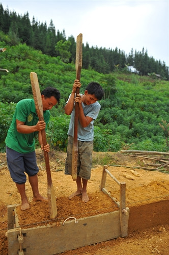 Tường nhà làm hoàn toàn bằng đất nện dày mà không có bất cứ cột hay cọc nào làm trụ. Để tạo nên những bức trình tường độc đáo, người Mông thường chọn loại đất có độ kết dính cao, loại bỏ sạch rễ cây, đá to, cỏ rác. Trước khi trình tường, người ta làm những chiếc khuôn gỗ có chiều dài 1,5 m, rộng chừng nửa mét. Sau đó đổ đất vào khuôn gỗ và dùng những chiếc vồ nện chặt đất.