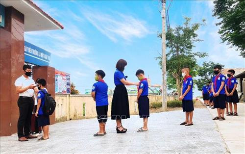 Thầy trò trường Tiểu học số 2 Quảng Văn (thị xã Ba Đồn, Quảng Bình) thực hiện nghiêm túc kiểm tra thân nhiệt và giữ khoảng cách. Ảnh: Võ Dung -TTXVN